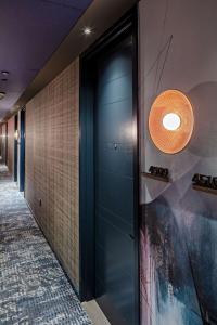 a hallway with a blue door and a tile wall at Tempo By Hilton New York Times Square in New York