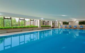 - une grande piscine d'eau bleue dans un bâtiment dans l'établissement DoubleTree by Hilton Shymkent, à Chimkent