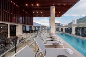 a hotel with a pool and tables and chairs at Hilton Monterrey in Monterrey