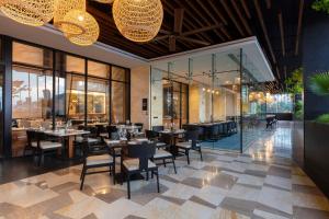 un restaurant avec des tables, des chaises et des parois en verre dans l'établissement Hilton Monterrey, à Monterrey