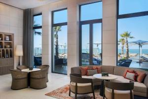 een hotellobby met tafels, stoelen en ramen bij Conrad Rabat Arzana in Rabat