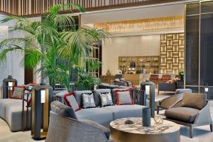 a lobby with couches and tables and palm trees at Conrad Rabat Arzana in Rabat