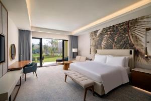 a bedroom with a large white bed and a television at Conrad Rabat Arzana in Rabat