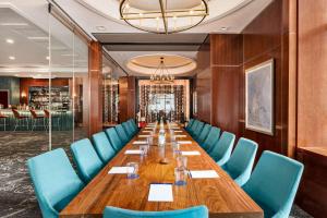 - une longue table dans une pièce avec des chaises bleues dans l'établissement DoubleTree by Hilton New York Midtown Fifth Ave, à New York