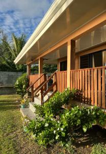 una casa con portico in legno e alcune piante di Villa Toa Pearl Bora Bora a Bora Bora