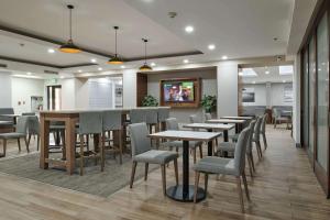 a restaurant with tables and chairs and a bar at Hampton Inn Ciudad Juarez in Ciudad Juárez