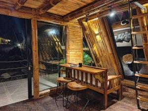a wooden room with a table and a bench at Senz Glamping - Mindo in Mindo