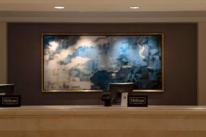 a waiting room with a large painting on the wall at Hilton Los Angeles Airport in Los Angeles