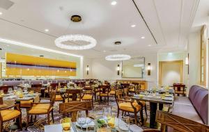 a restaurant with tables and chairs in a room at Hilton Los Angeles Airport in Los Angeles