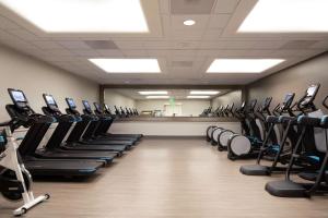 a gym with rows of treadmills and exercise bikes at Hilton Los Angeles Airport in Los Angeles