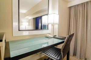 a desk in a hotel room with a laptop and a phone at Hilton Los Angeles Airport in Los Angeles