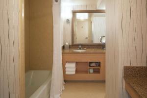 a bathroom with a tub and a sink and a mirror at Hilton Los Angeles Airport in Los Angeles