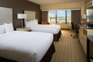 a hotel room with two beds and a large window at Hilton Los Angeles Airport in Los Angeles