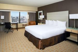 a hotel room with a large bed and a desk at Hilton Los Angeles Airport in Los Angeles