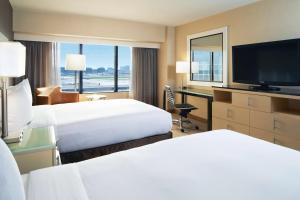 a hotel room with two beds and a flat screen tv at Hilton Los Angeles Airport in Los Angeles