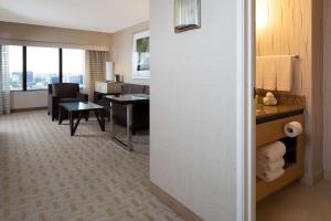 a hotel room with a desk and a living room at Hilton Los Angeles Airport in Los Angeles