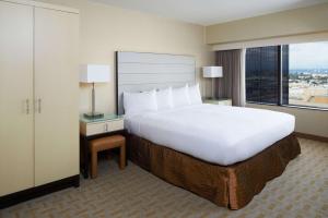 a large bed in a hotel room with a large window at Hilton Los Angeles Airport in Los Angeles