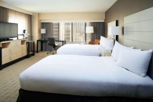 a hotel room with two beds and a television at Hilton Los Angeles Airport in Los Angeles