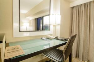 a desk in a hotel room with a phone at Hilton Los Angeles Airport in Los Angeles