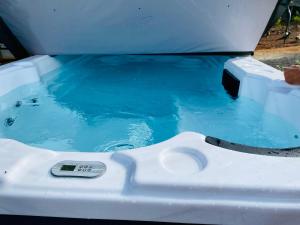 a hot tub with a remote control in it at Sandalwood Downs Fabulous Farm Stay TOODYAY in Toodyay