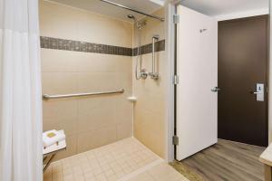a shower with a glass door in a bathroom at DoubleTree by Hilton Hotel New York City - Chelsea in New York