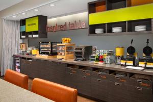 a restaurant with a prepared table with orange chairs at Home2 Suites by Hilton Lexington University / Medical Center in Lexington