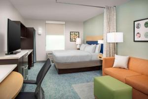 une chambre d'hôtel avec un lit et un canapé dans l'établissement Home2 Suites by Hilton Lexington University / Medical Center, à Lexington