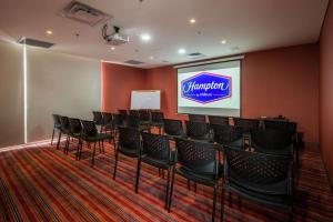Hampton by Hilton Bogota Usaquen في بوغوتا: قاعة اجتماعات مع كراسي وشاشة عرض
