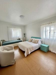 una camera con due letti e un divano in camera di A Villa Fortuna a Santo André