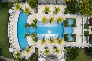 an aerial view of a resort pool with palm trees at Indura Beach & Golf Resort Curio Collection By Hilton in Tela