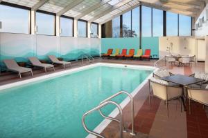 una piscina con sillas y mesas en un edificio en DoubleTree by Hilton Manchester Downtown, en Manchester