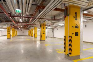 an empty parking lot with yellow columns in a parking garage at Hampton By Hilton Bialystok in Białystok