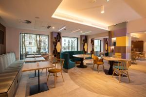 a restaurant with wooden tables and chairs and windows at Hampton By Hilton Bialystok in Białystok +55 photos