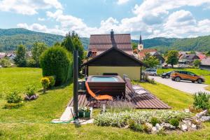 a person sitting in a chair on a deck in front of a house at Apartments for families with children Prezid, Gorski kotar - 20260 in Prezid