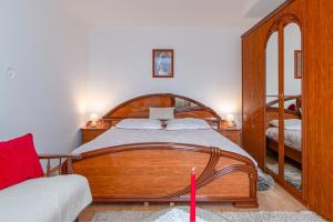 1 dormitorio con cama de madera con cinta rosa en Apartments for families with children Prezid, Gorski kotar - 20260 en Prezid