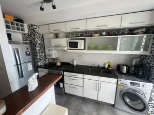 a kitchen with a sink and a washing machine at MANU. Moderno 2 dormitorios grande y luminoso. 2 baños. Cochera. Amenities in Rosario