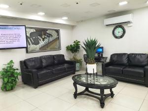 a waiting room with black leather couches and a table at Hotel Marques de Cima in Nogales
