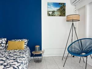 Zimmer mit einem Bett und einer blauen Wand in der Unterkunft Studio de l'Anse Mitan in Les Trois-Îlets