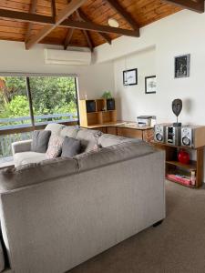 a living room with a gray couch in a room at Bach on Daisy in Tauranga
