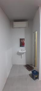 a white room with a sink and a mirror at Madak Ekas homestay in Ekas