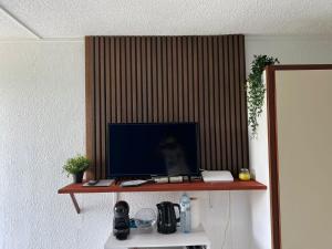 un monitor su una mensola in una stanza di Studio de l'Anse Mitan a Les Trois-Îlets