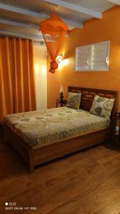a bed in a bedroom with an orange wall at Concept Kreyol in Sainte-Rose +9 photos