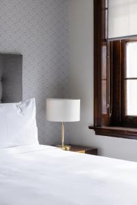Southern Cross Hotel في سيدني: غرفة نوم بسرير وطاولة مع مصباح