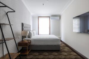 um quarto branco com uma cama e uma janela em Southern Cross Hotel em Sydney