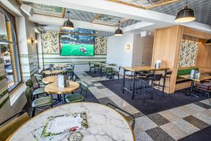 a restaurant with tables and chairs and a large screen at Southern Cross Hotel in Sydney