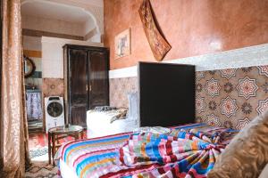 a bedroom with a bed with a colorful blanket at Héritage Lalla Aicha Hotel & Spa in Marrakesh