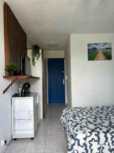 ein Schlafzimmer mit einem Bett und einer blauen Tür in der Unterkunft Studio de l'Anse Mitan in Les Trois-Îlets