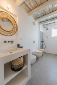 a bathroom with a sink and a toilet and a mirror at Villa da Comporta - Quarto Praia da Comporta T0 in Comporta