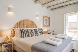 Un dormitorio con una cama grande con almohadas. en Villa da Comporta - Quarto Praia da Comporta T0 en Comporta