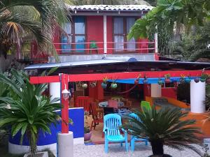 Barra de Santiago的住宿－MARDEORO BEACH HOUSE，色彩缤纷的房子前面设有桌椅